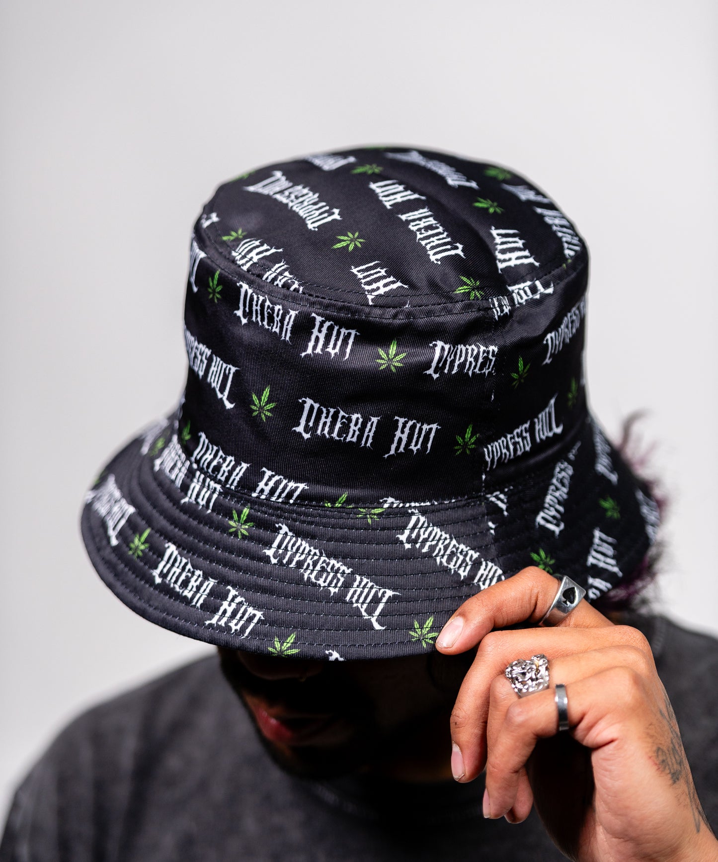 Image of the reverse side of the bucket hat, which features the words "Cheba Hut" "Cypress Hill" and also has small green marijuana leaves on it.