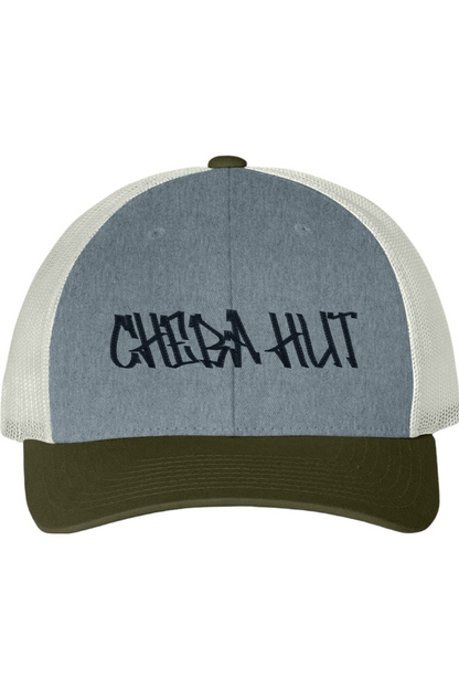 A six panel Trucker hat with 'CHEBA HUT' text on a white background. The bill is an olive green and the front panel is grey. The side mesh is an off white. 