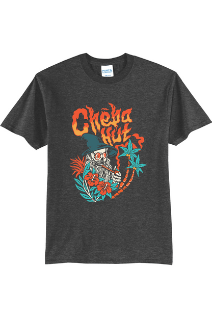 A charcoal short-sleeved t-shirt featuring a colorful graphic on the back depicting a wizard-like figure with a long white beard, a pointed hat, sunglasses, and a pipe, surrounded by flames, hibiscus flowers, and palm trees, with the 'Cheba Hut' logo above.